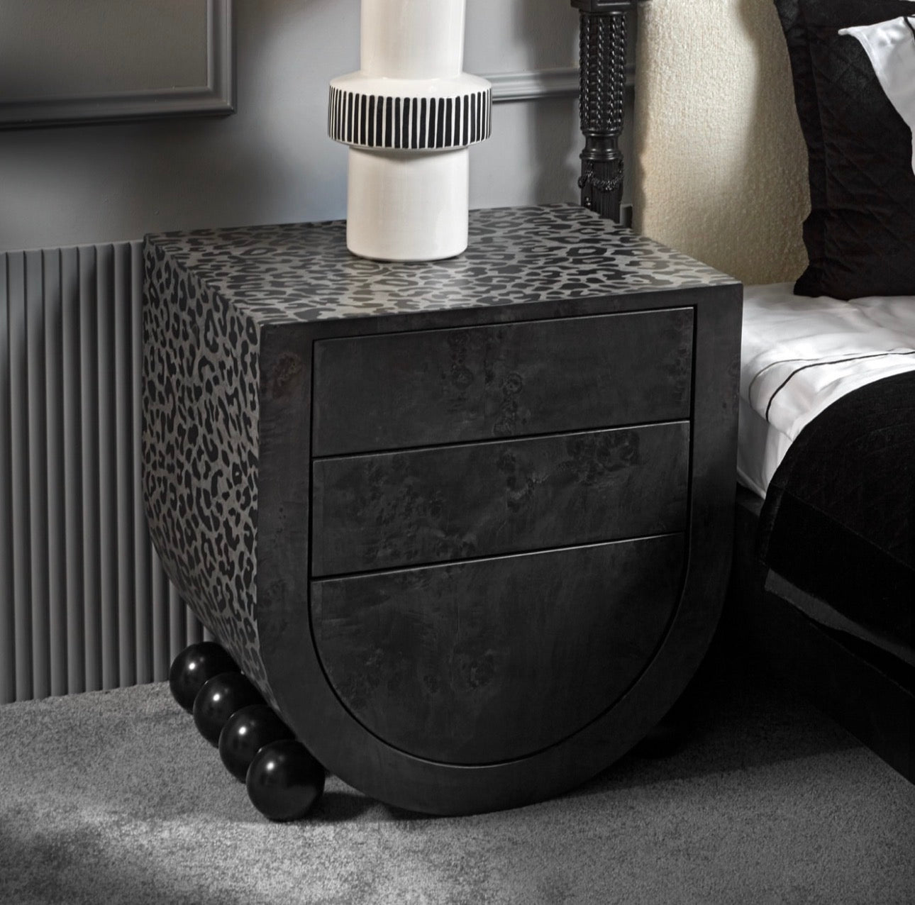 Panthera luxury furniture collection featuring statement sofa, sculptural coffee table, pedestal table, and modern shelving in dark finishes.