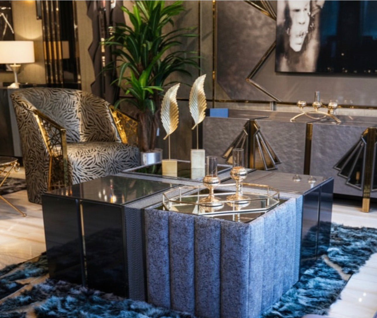 Frost luxury furniture collection featuring geometric wall mirror, dark lacquer sideboard with gold accents, and patterned armchairs with sculptural brass frames.