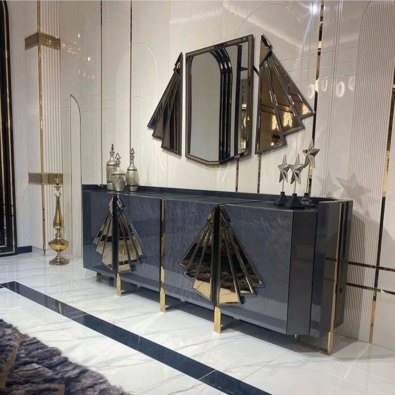 Frost luxury furniture collection featuring geometric wall mirror, dark lacquer sideboard with gold accents, and patterned armchairs with sculptural brass frames.