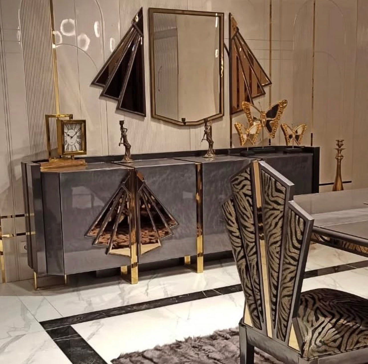 Frost luxury furniture collection featuring geometric wall mirror, dark lacquer sideboard with gold accents, and patterned armchairs with sculptural brass frames.